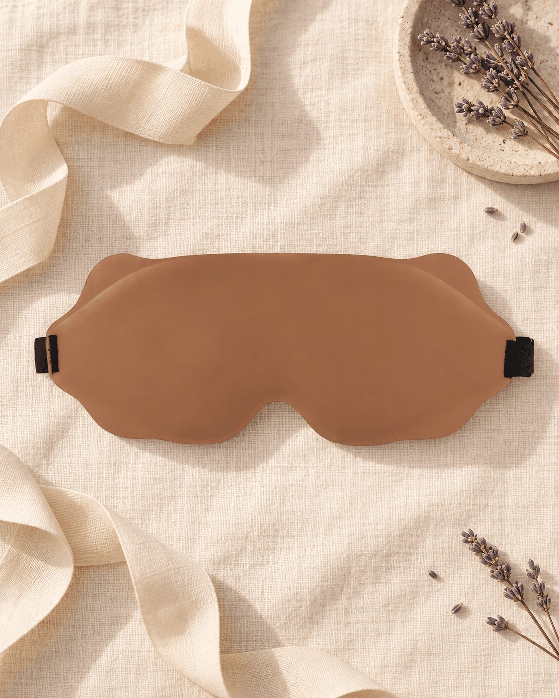 Flat lay of the Sleep Reset Mask in Sand with a cream ribbon, stone dish and dried lavender