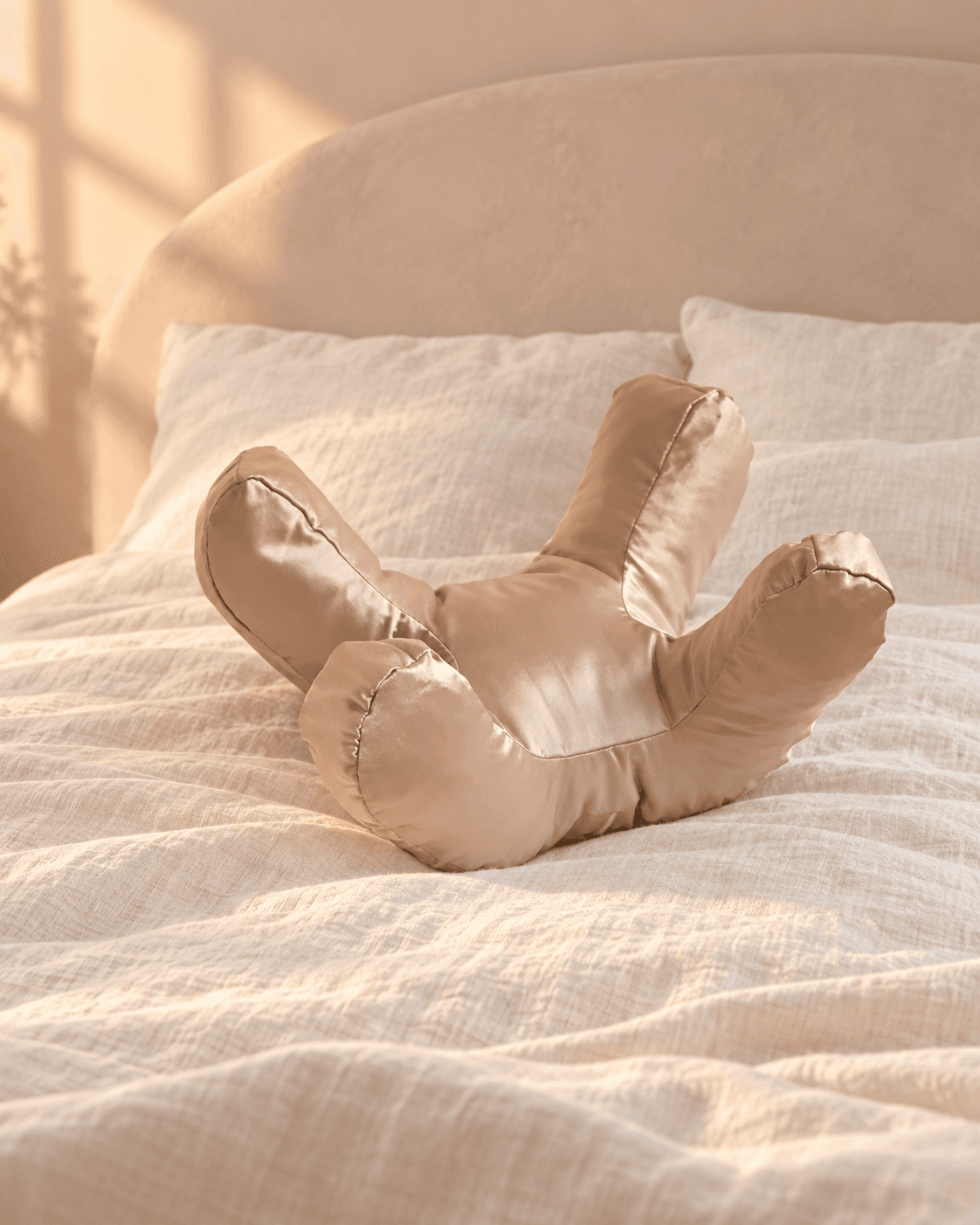 Beauty Sleep Cradle in champagne-sand satin on an ivory linen bed